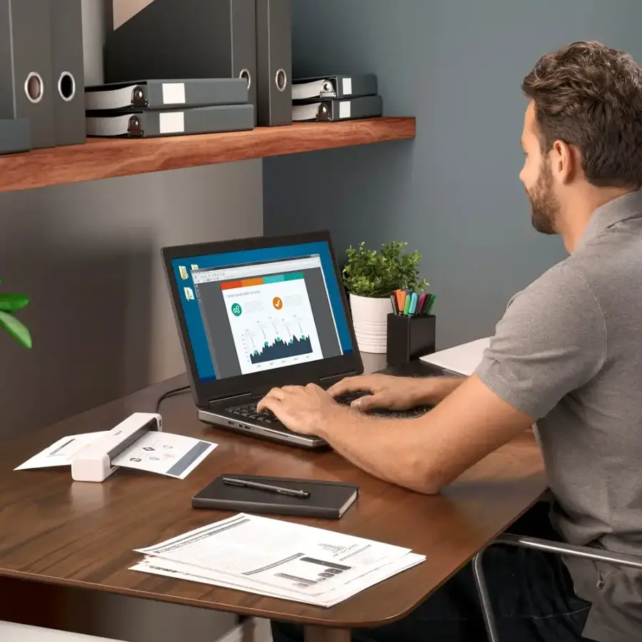 I'm sorry, but the image does not have any text or description that can be grouped or corrected. The image shows a man sitting at a desk with a laptop, but there is no text or description provided.