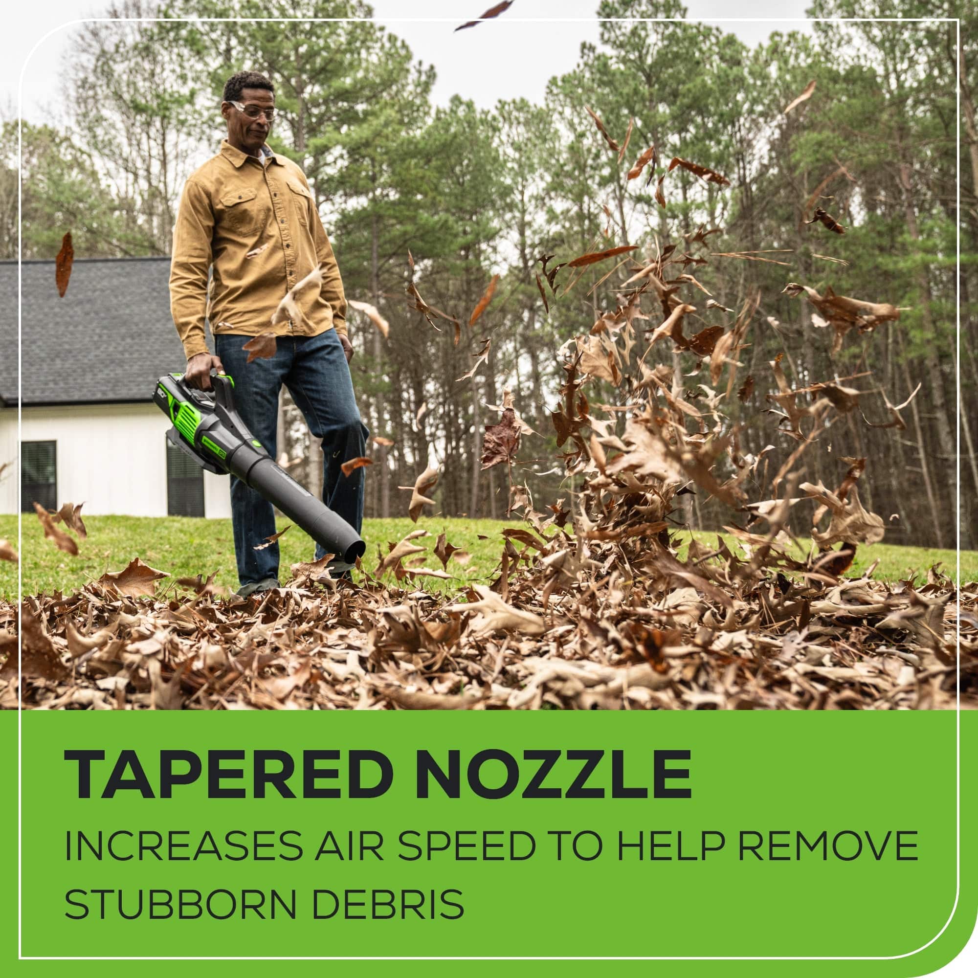The image features a man standing in a pile of leaves, holding a leaf blower with a tapered nozzle. The tapered nozzle increases air speed to help remove stubborn debris, making it an effective tool for clearing leaves and other debris from outdoor spaces.