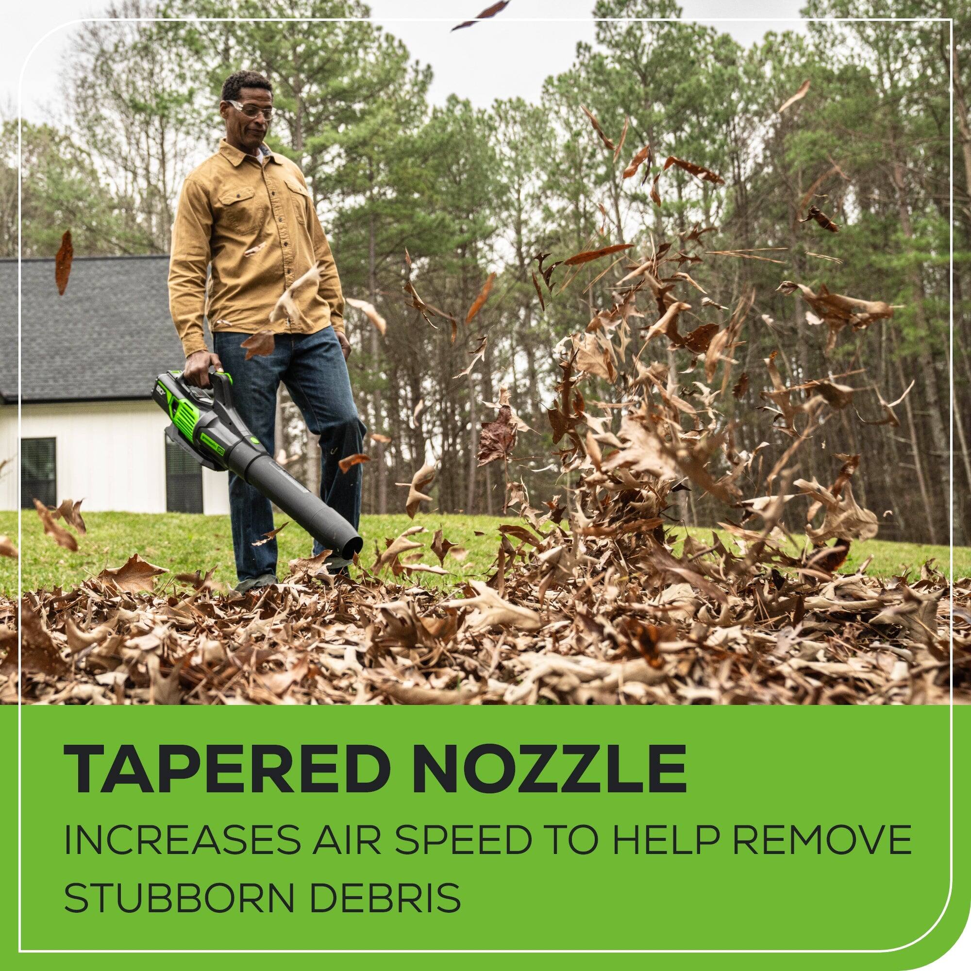The image features a man standing in a pile of leaves, holding a leaf blower with a tapered nozzle. The tapered nozzle increases air speed to help remove stubborn debris, making it an effective tool for clearing leaves and other debris from outdoor spaces.