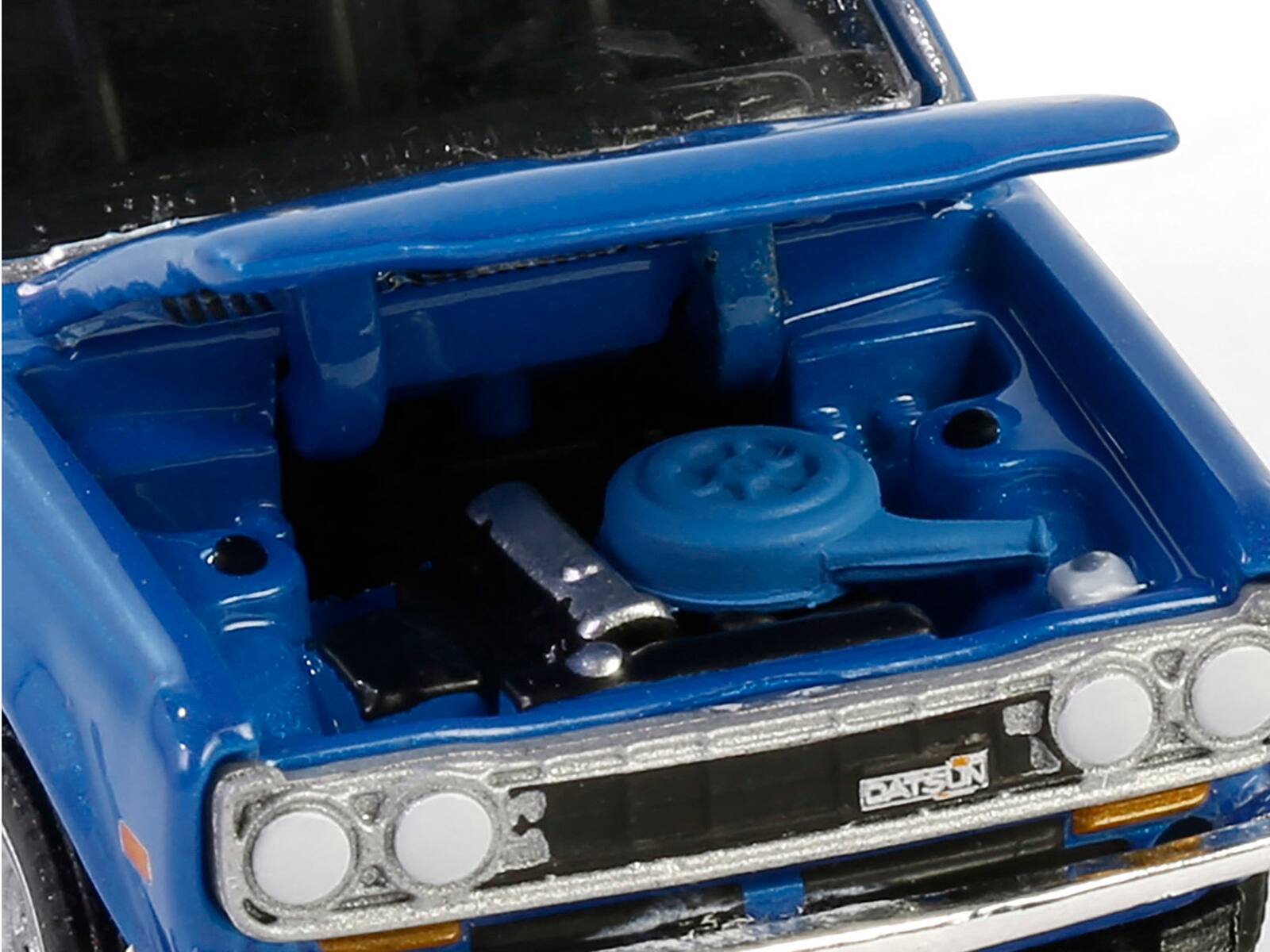 Angle. Greenlight - 1972 Datsun 510 Blue Metallic with White Stripes "Show it Like it is - a Champion" "Vintage Ad Cars" Series 11 1/64 - Blue Metallic with White Stripes.