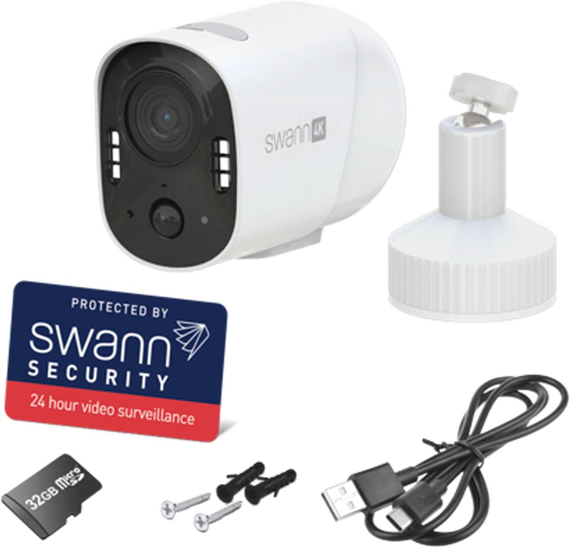 The image features a white Swann security camera with a 32GB memory card, a USB cable, and a power adapter. The camera is protected by Swann Security and offers 24-hour video surveillance. The image also includes a Swann Security sticker, which indicates the product's affiliation with the company.