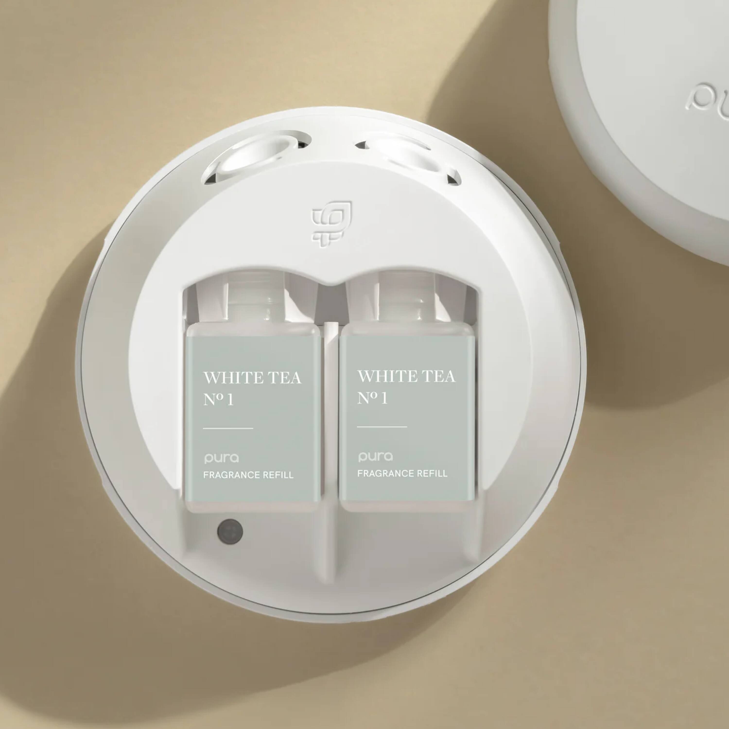 The text on the image reads: "OU a WHITE TEA N 1 WHITE TEA N1 1 pura FRAGRANCE REFILL pura FRAGRANCE REFILL".