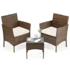 The image features two wicker chairs placed next to each other on a white background. The chairs are accompanied by a small table, which has a book and a vase on it. The chairs are arranged in a way that they face each other, creating a comfortable and inviting seating area. The overall scene exudes a sense of relaxation and leisure.