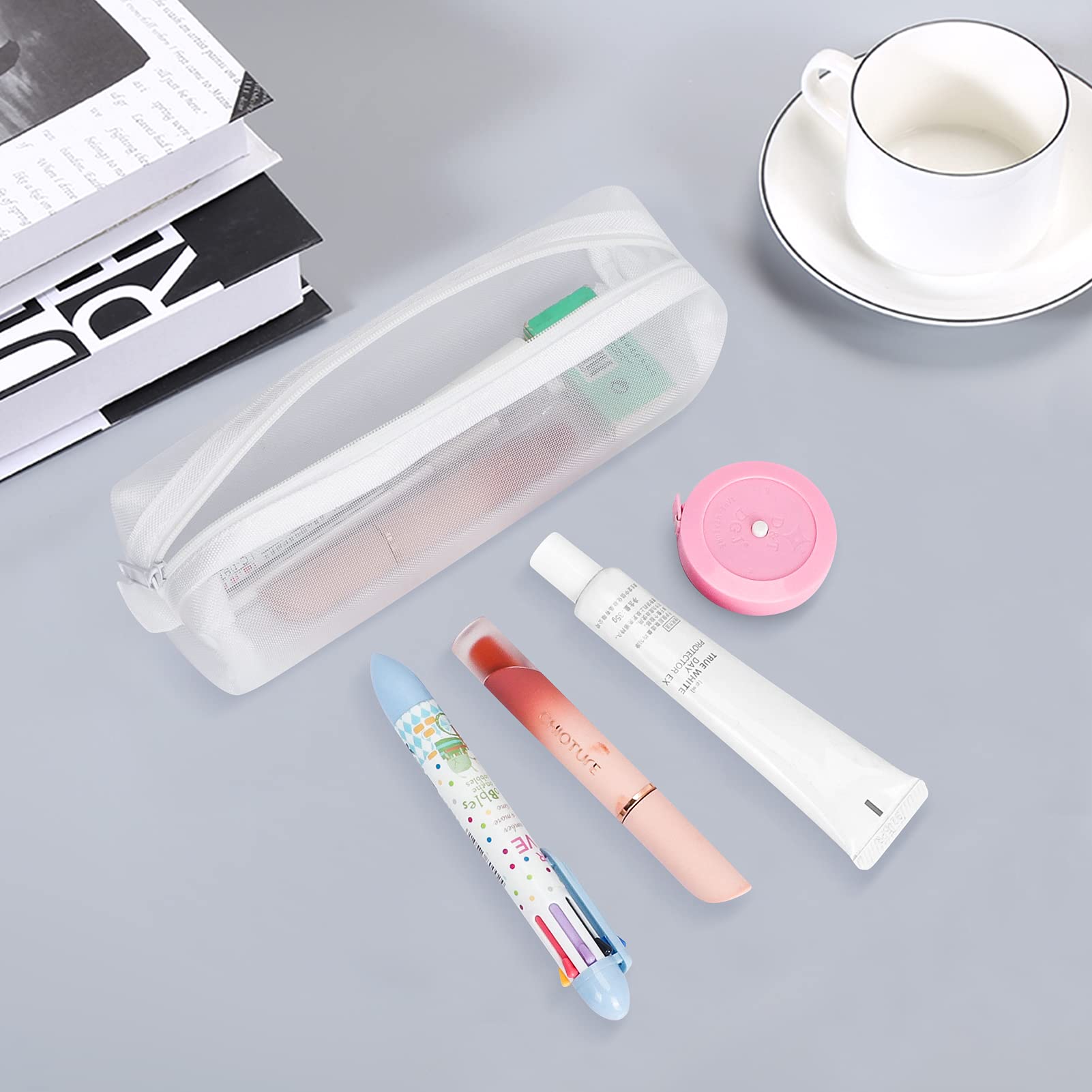 Sure, here is the corrected and grouped text from the image:

**Top Left (Book):**
- "DRY"

**Bottom Left (Lip Balm):**
- "BIO"
- "LIP BALM"
- "MOISTURE"

**Bottom Center (Lipstick):**
- "MOISTURE"

**Bottom Right (Lip Balm):**
- "LIP BALM"

**Top Right (Cup):**
- No visible text.

**Top Center (Mesh Pouch):**
- No visible text.

**Top Center (Mesh Pouch Contents):**
- No visible text.

**Top Center (Mesh Pouch Contents):**
- No visible text.

**Top Center (Mesh Pouch Contents):**
- No visible text.

**Top Center (Mesh Pouch Contents):**
- No visible text.

**Top Center (Mesh Pouch Contents):**
- No visible text.

**Top Center (Mesh Pouch Contents):**
- No visible text.

**Top Center (Mesh Pouch Contents):**
- No visible text.

**Top Center (Mesh Pouch Contents):**
- No visible text.

**Top Center (Mesh Pouch Contents):**
- No visible text.

**Top Center (Mesh Pouch Contents):