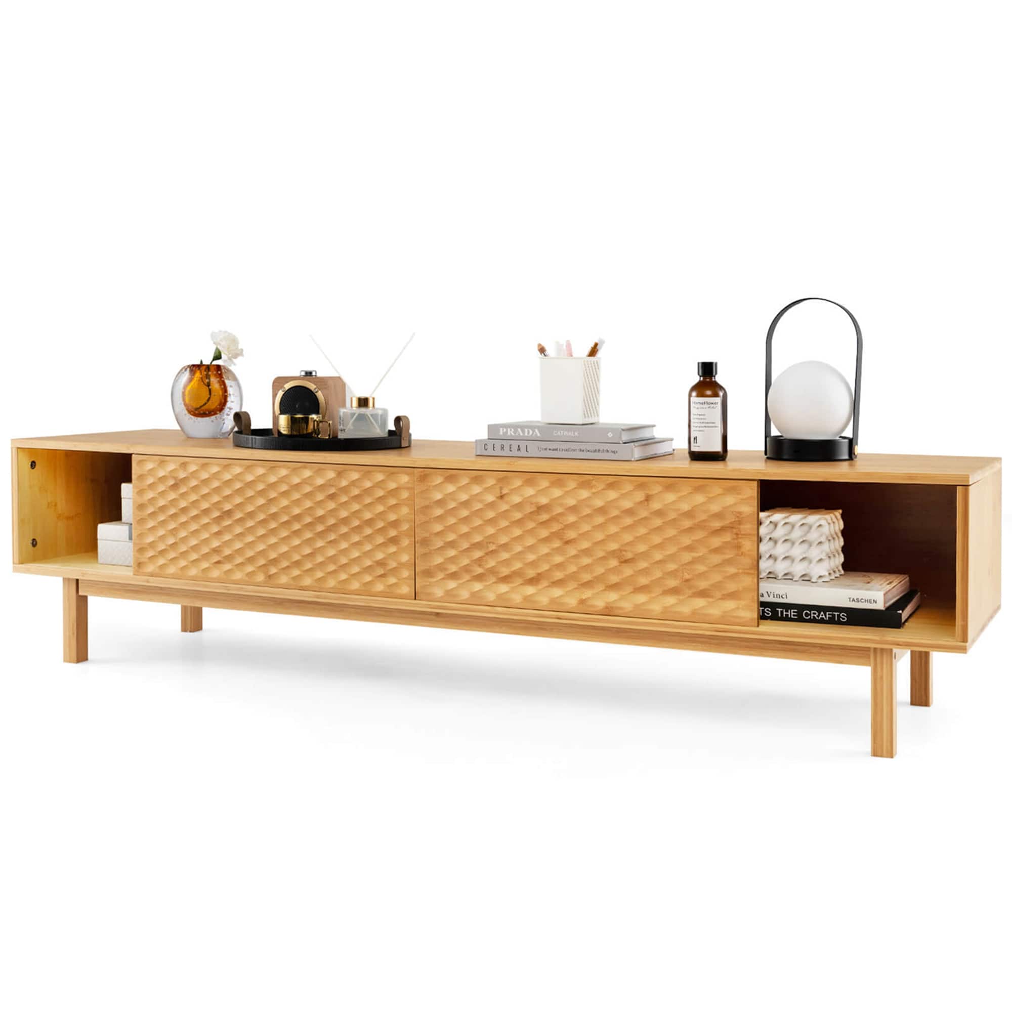 The image features a wooden table with a variety of items on it. There are several books, a bottle, a clock, a lamp, and a bowl. The table also has a drawer with a book in it. The arrangement of these items creates an organized and functional space.