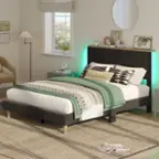 "In the image, there is a bed with a green and white blanket and a striped pillow. The bed is in a bedroom with a window and a chair nearby. There is also a clock on the wall and a mirror above the bed. The room is decorated with various items, such as a potted plant, a vase, and a bowl. The overall atmosphere of the room is cozy and inviting."