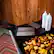 The image features a wooden table with a cutting board and various food items, including potatoes, apples, and bananas. There are also two bottles of Blackstone seasoning on the table. The table is set up for food preparation, with the cutting board and food items ready for use.
