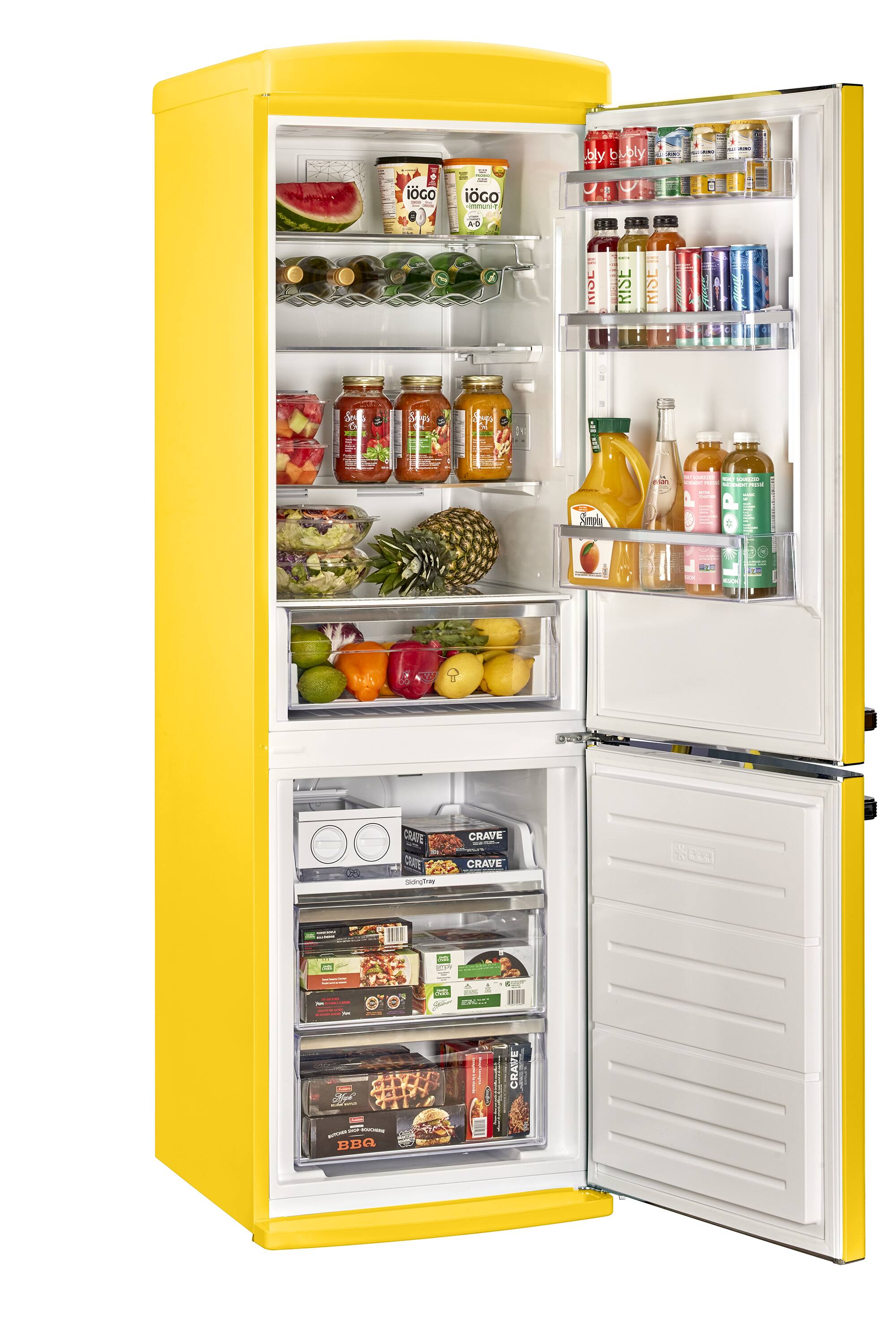 The yellow refrigerator is filled with various food items and drinks. The refrigerator has a total of 13 bottles, with some placed on the top shelves and others on the bottom shelves. There are also 12 oranges, which are scattered throughout the refrigerator, with some placed in the middle and others on the top and bottom shelves. Additionally, there are 11 apples, which are also distributed across the refrigerator, with some on the top shelves and others on the bottom shelves. The refrigerator is well-stocked with a variety of food and drinks, making it a convenient and accessible place for meal preparation and storage.