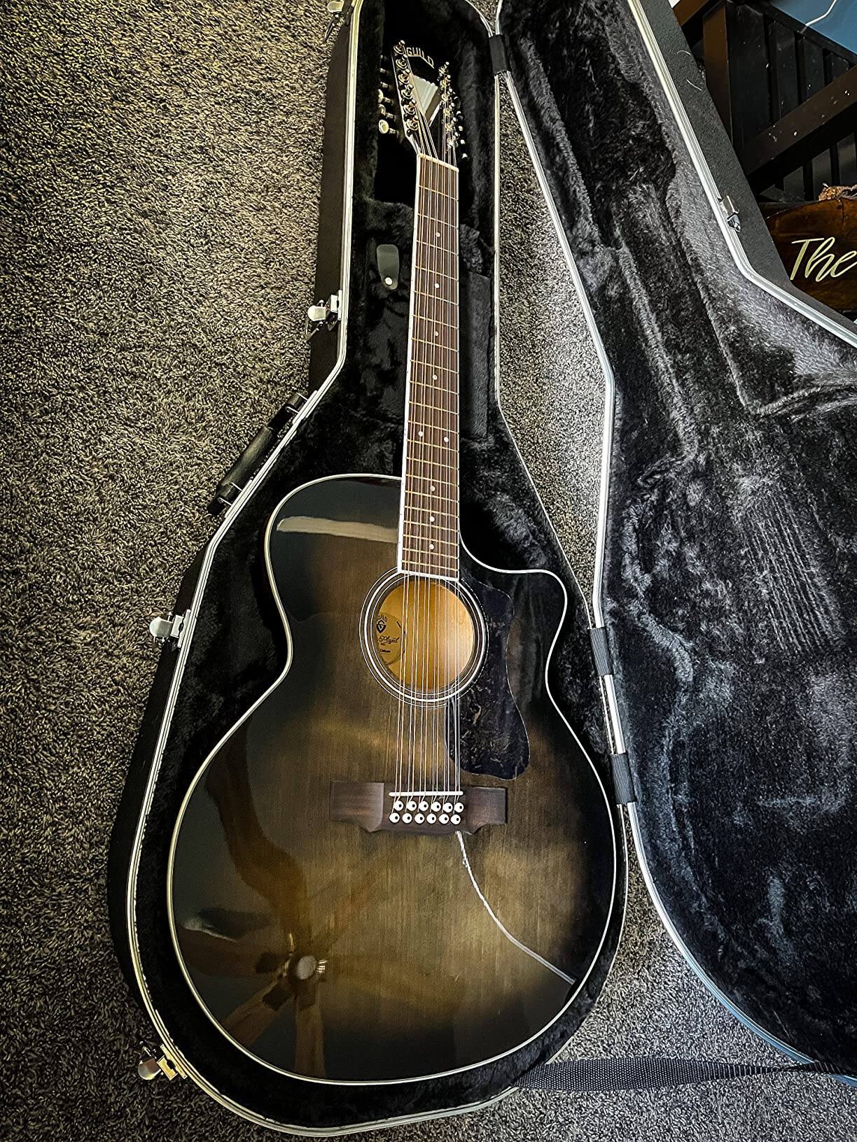 The guitar is placed inside an open black case with a plush interior.
