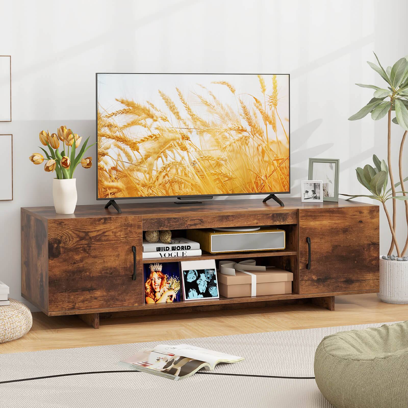 The image features a flat screen TV placed on top of a wooden entertainment center. The TV is displaying a picture of wheat, and there are several books and a vase nearby. Additionally, there are two potted plants in the room, one on the left side and another on the right side. The room also contains a couch, which is located on the right side of the image.