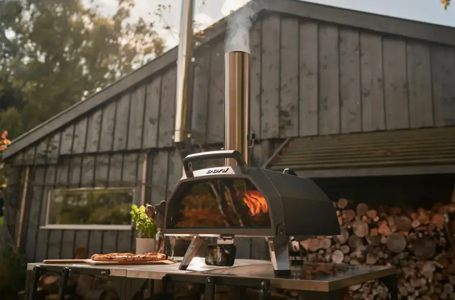 The text "850 DON D00" is not present in the image. The image features a pizza oven, a table with pizza, and a building in the background.