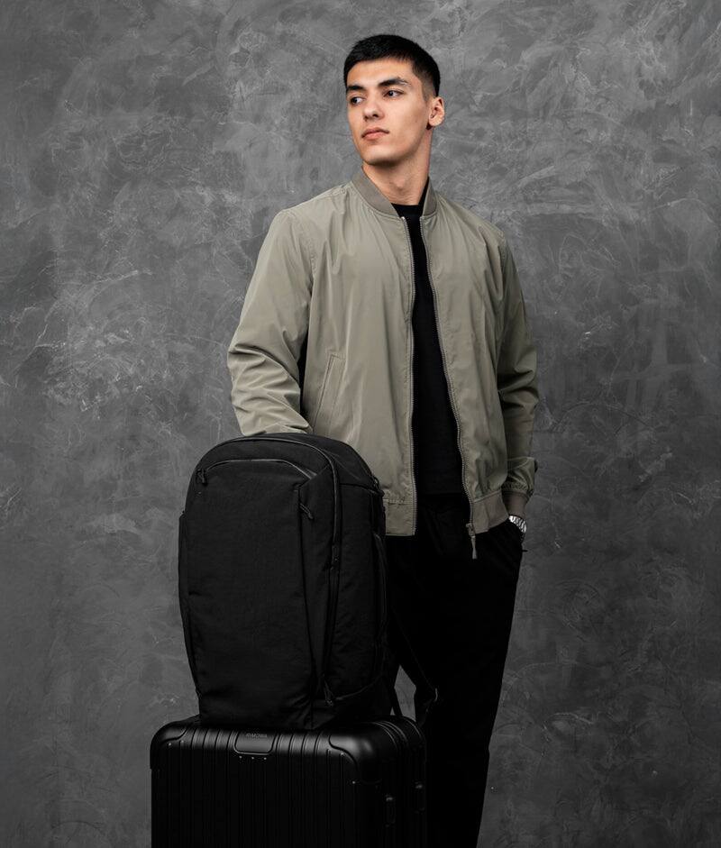 Angle. ALPAKA - Traverse Backpack Laptop Backpack for Men, Backpack with Laptop Compartment (16"), Clamshell Travel Pack, Bottle Sleeve - Black Axoflux 400D Ripstop Nylon.
