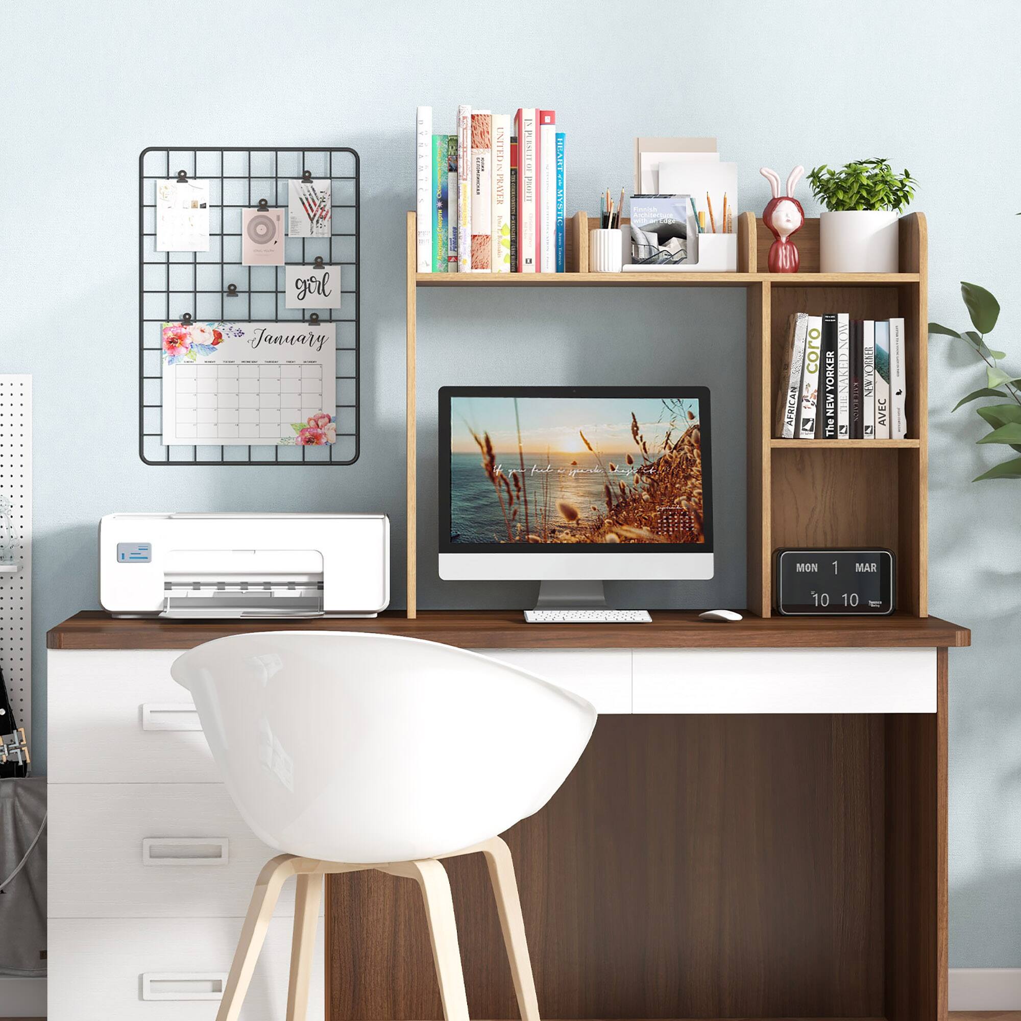 The image features a desk with a computer, keyboard, and mouse. There is a calendar on the wall, and a bookshelf with various books. A chair is positioned in front of the desk. Additionally, there are two potted plants in the room, one on the left side and another on the right side. A clock is also present on the wall, and a vase is placed on the desk. The scene appears to be a well-organized workspace.