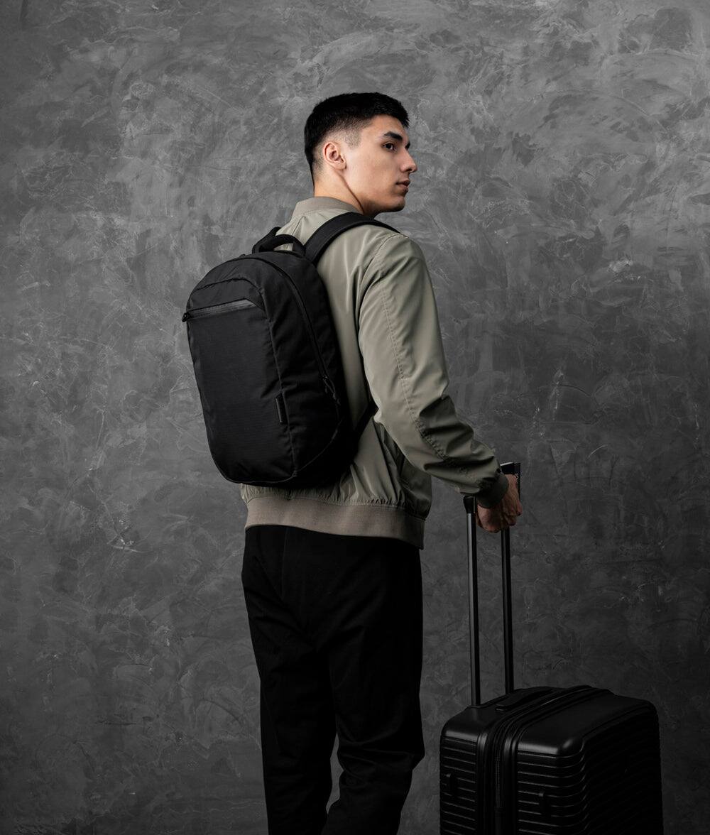 Angle. ALPAKA - Essential Backpack 16L Laptop Backpack for 16" Laptop, Travel Backpack with Water-Resistant Design - Black Axoflux 210D.
