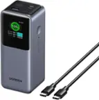 The image features a UGREEN power strip with a green light on it. The power strip is connected to a charger, and there are two cords coming out of it. The charger is plugged into the wall, and the power strip is sitting on a table. The power strip is designed to provide a stable and reliable source of power for various electronic devices.