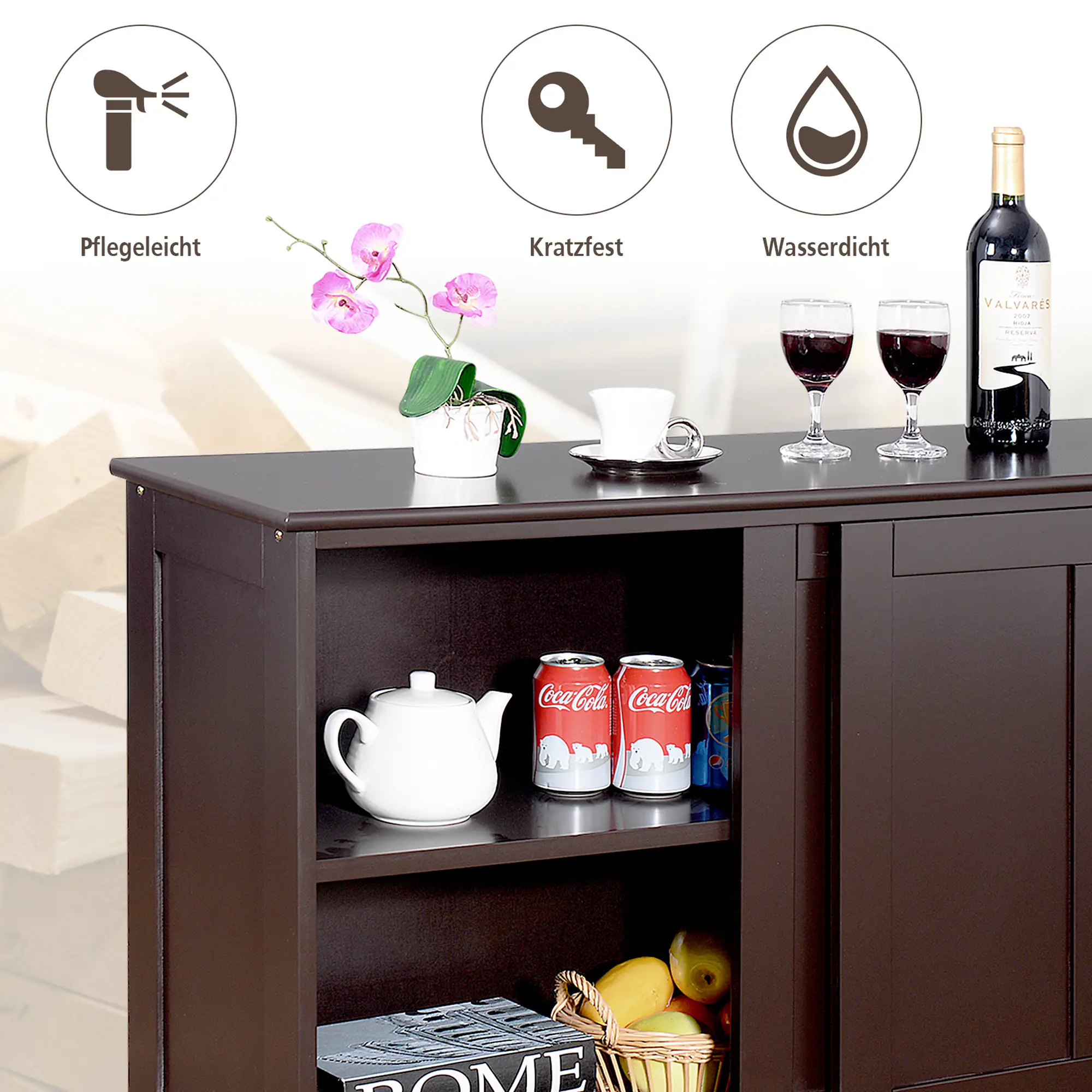 The text on the image reads: "Pflegeleicht Kratzfest Wasserdicht - VALVARES aust ... ml Coca-Cola Coca-Cola OME." This text is in German, and it can be grouped and corrected as follows:

"Pflegeleicht Kratzfest Wasserdicht - Valvases aus ... 1,5 l Coca-Cola Coca-Cola OME."

The text is describing a table with a variety of items on it, including a basket of fruit, a vase with flowers, and a cup. The table is also holding a bottle of wine and a bottle of Coca-Cola.