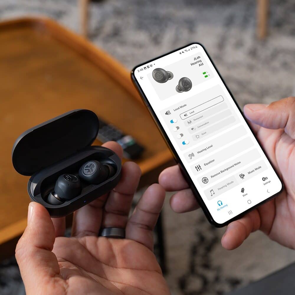 The text on the image is a description of a hearing aid, which is a device designed to help people with hearing loss. The hearing aid is made by JLab and is specifically designed for low-frequency hearing loss. It features a conversation mode that adjusts the volume and equalizer settings to enhance speech clarity during conversations. Additionally, the hearing aid has a noise reduction mode that helps to filter out background noise, and a music mode that is optimized for listening to music. The user can also adjust the volume and other settings to suit their specific hearing needs.