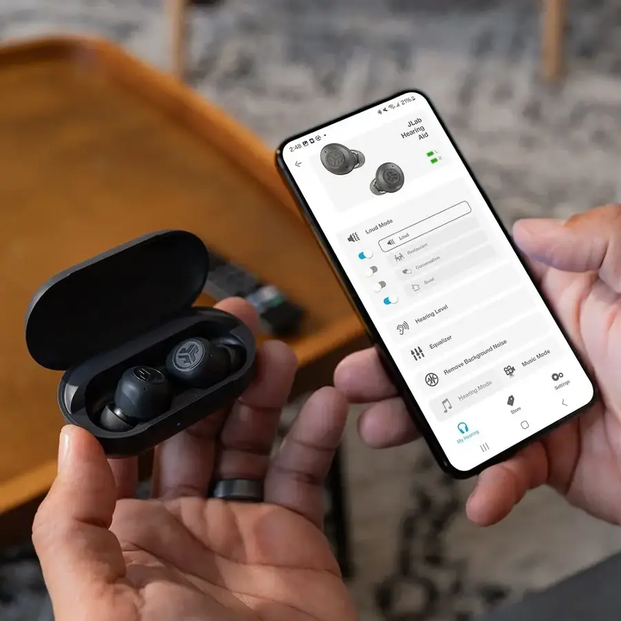 The text on the image is a description of a hearing aid, which is a device designed to help people with hearing loss. The hearing aid is made by JLab and is specifically designed for low-frequency hearing loss. It features a conversation mode that adjusts the volume and equalizer settings to enhance speech clarity during conversations. Additionally, the hearing aid has a noise reduction mode that helps to filter out background noise, and a music mode that is optimized for listening to music. The user can also adjust the volume and other settings to suit their specific hearing needs.