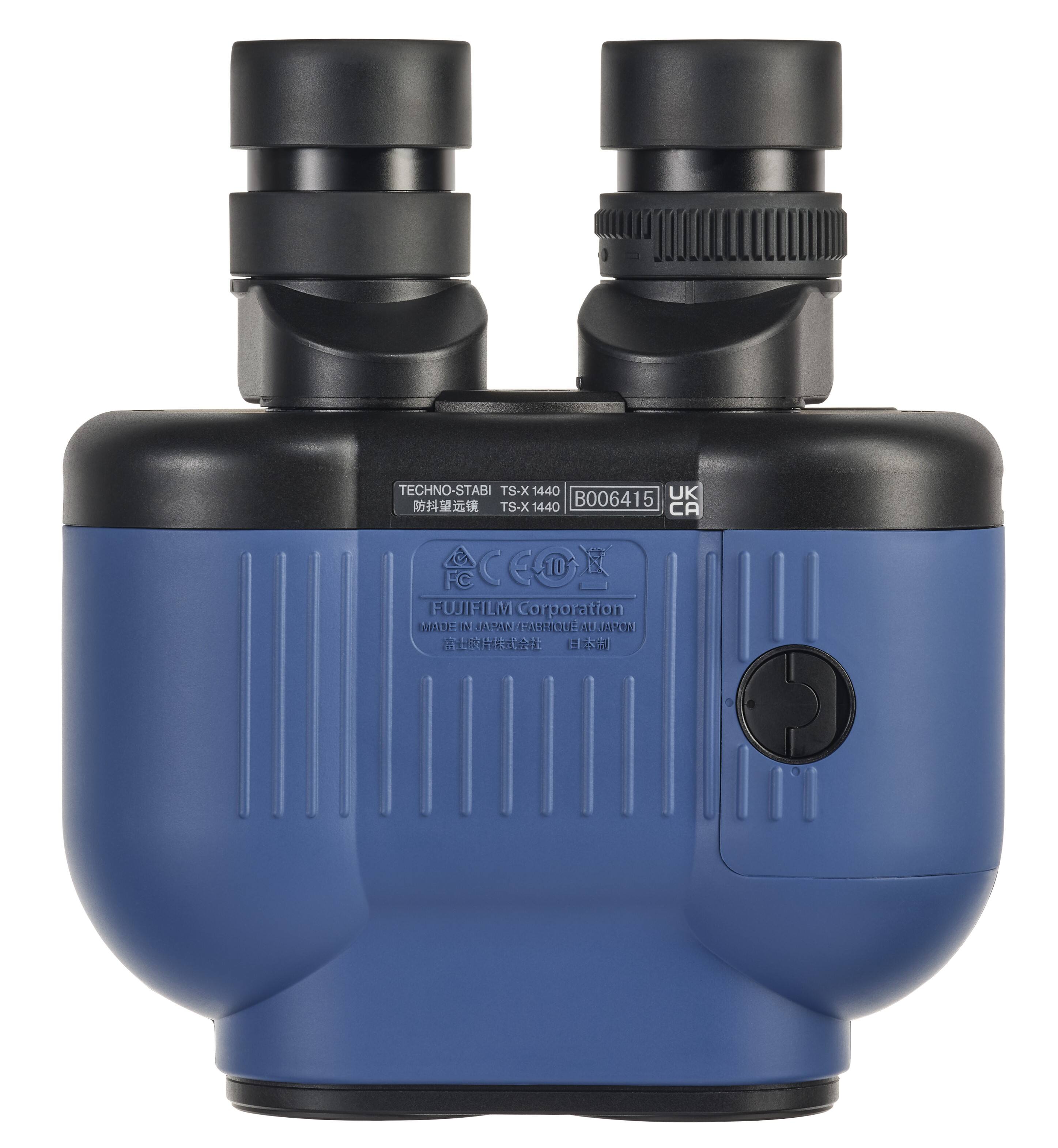 The image features a blue device with a black top, which is a Techno-Stabi TS-X 1440 UK. The device is made by Fujifilm Corporation and has a CCOE 10 FC lens. The blue case is designed to protect the device and its lens.