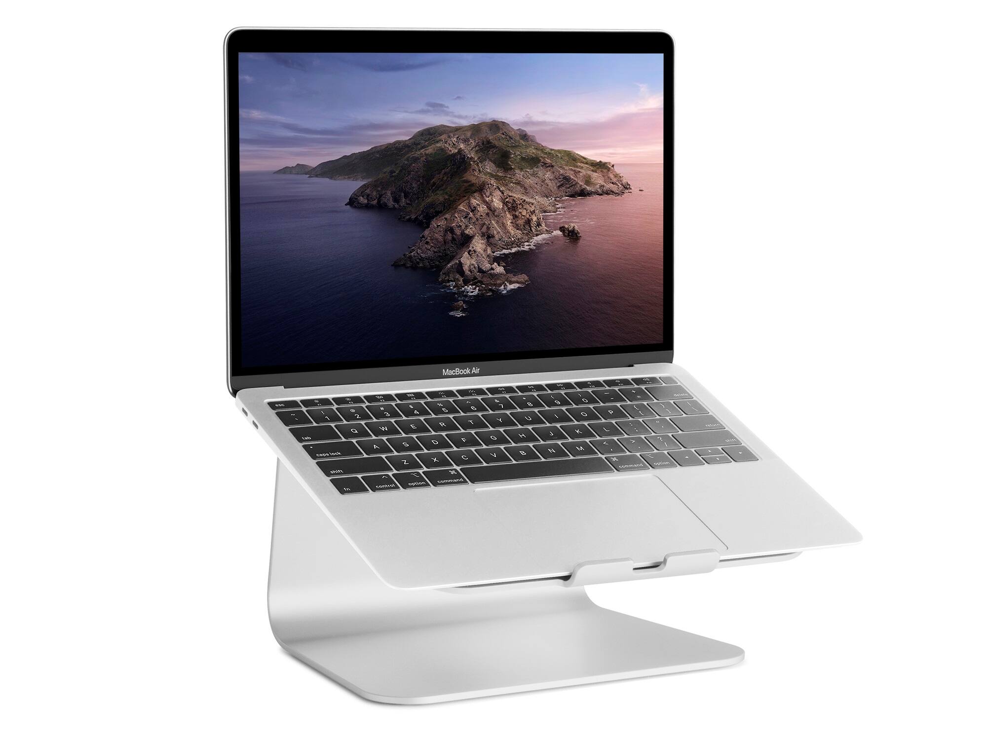 The image features a MacBook Air laptop computer with a large screen. The laptop is sitting on a stand, which elevates the screen to a more comfortable viewing angle. The laptop is open, displaying a beautiful image of a mountain island.