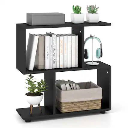 The image features a black bookshelf with a variety of items on it. There are several books of different sizes, a potted plant, and a pair of headphones. The headphones are placed on the shelf, along with the books, creating a cozy and organized space for reading and listening to music. The combination of the books, headphones, and plant adds a touch of personalization and warmth to the space.