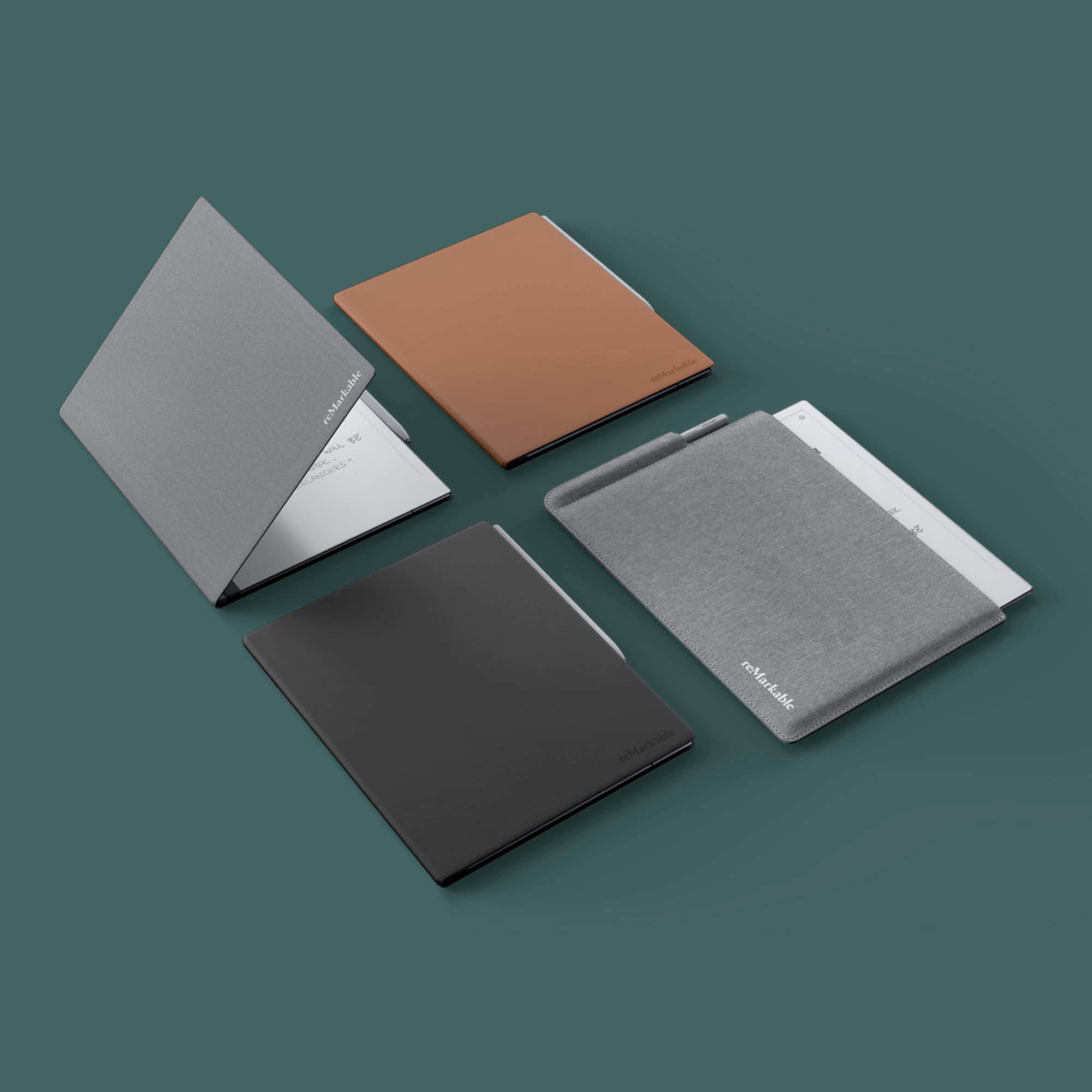 The image features four books, each with a different color. The books are arranged in a square formation, with one book on each side. The colors of the books are black, brown, gray, and white. The books are displayed on a table, and they are all closed. The brand of the books is reMarkable, and they are designed for writing, drawing, and note-taking.