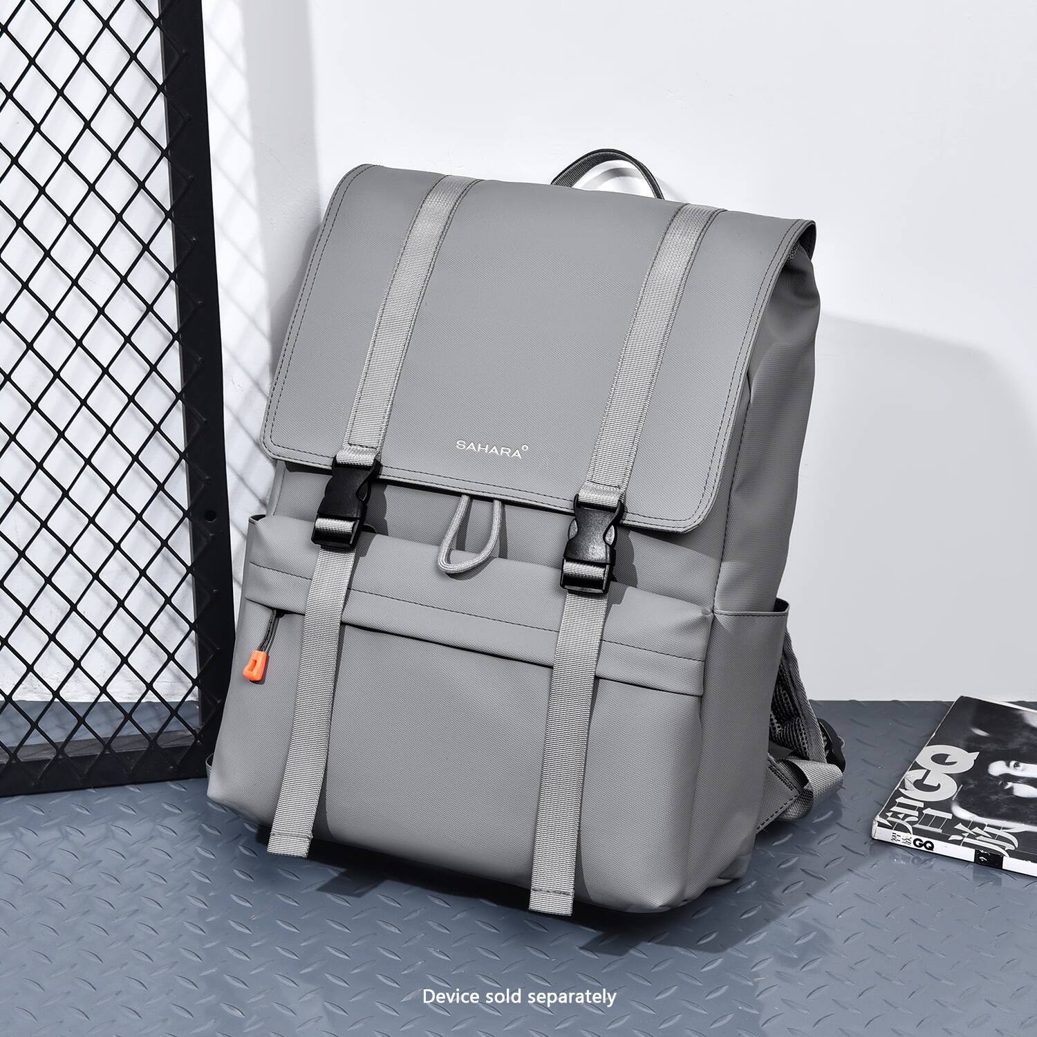 The image features a grey backpack with a strap, which is placed in front of a fence. The backpack is from the brand Sahara and is available for sale separately.