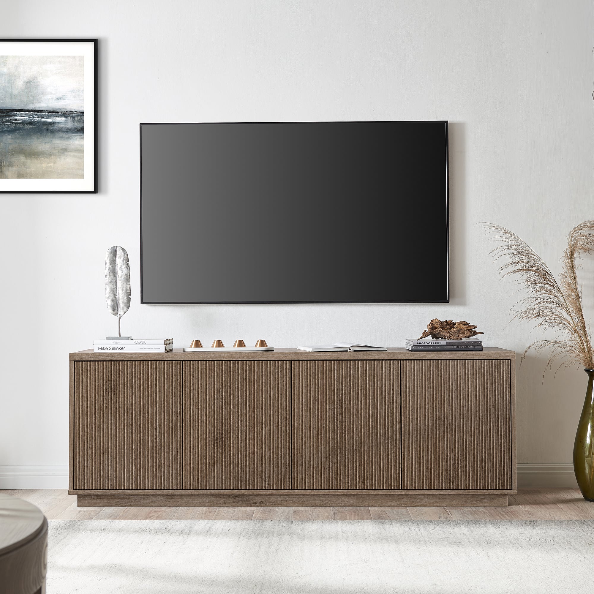 I'm sorry, but I cannot group or correct the text "Uae ereer -" as it does not provide any context or information about the image. The image features a flat screen TV on top of a wooden cabinet, and there is a vase and a book on the table.