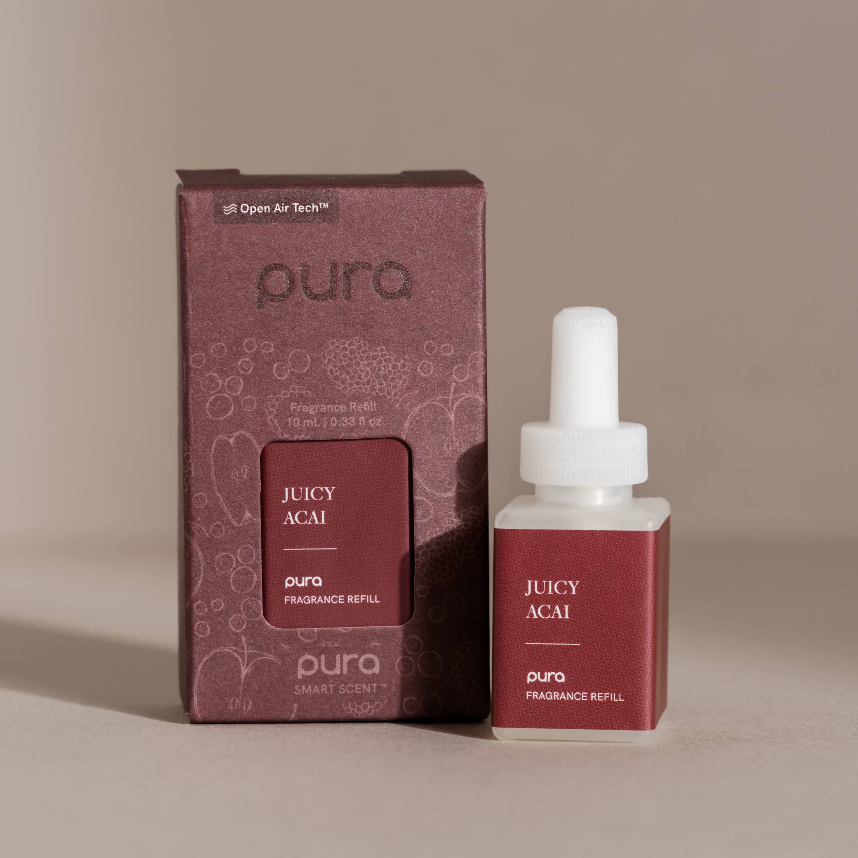 The image features a box of pura Fragrance Refills, which contains a 10 mL bottle of Juicy Acai pura Smart Scent. The box is red and has a white cap, while the bottle is white. The box is placed next to the bottle, creating an appealing presentation for the product.