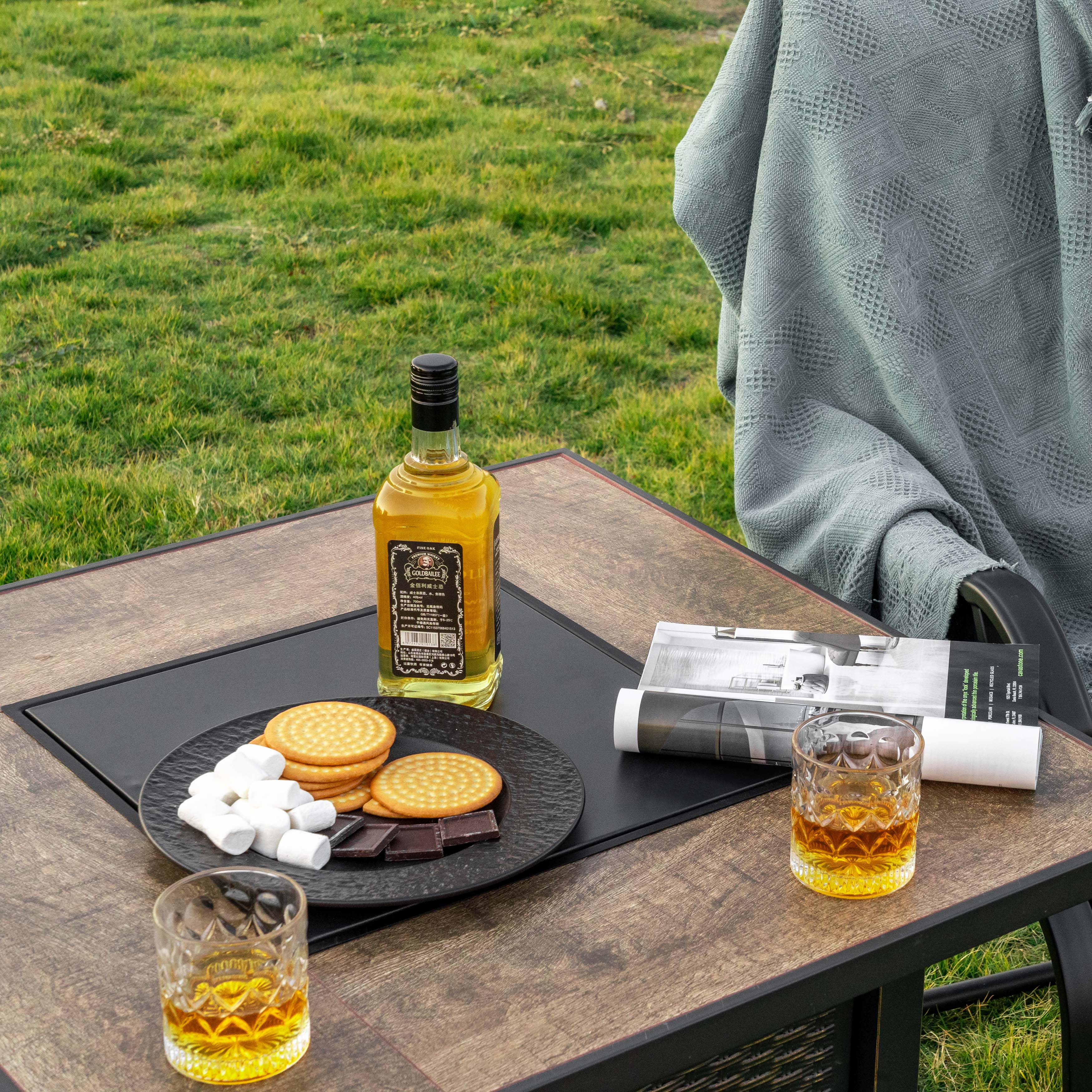 Angle. Nuu Garden - 30'' Outdoor Metal Gas Fire Pit Table with Lid and Lava Rocks - black with gold-painted edge, brown.