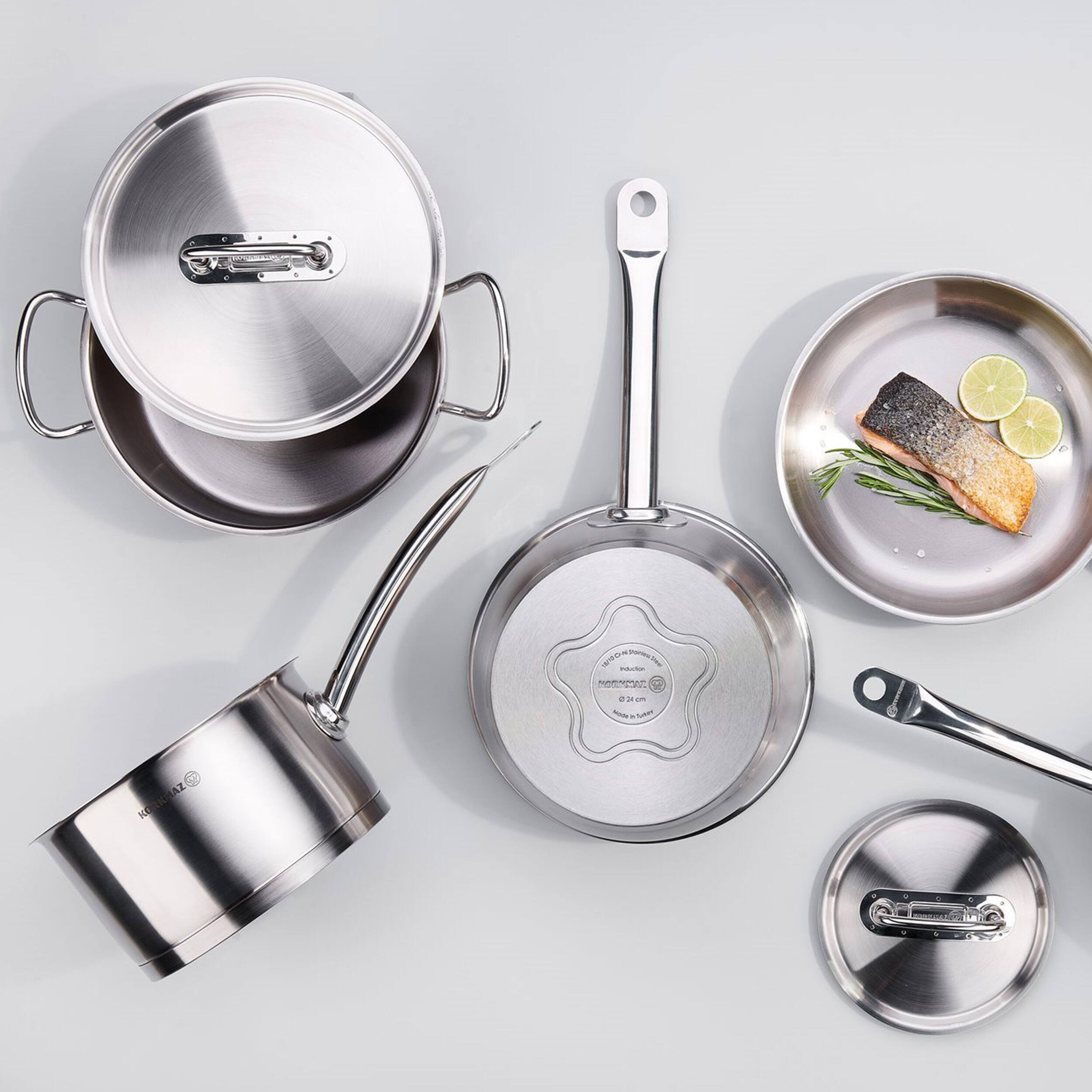 The image features a variety of kitchen utensils and cookware, including a pan, a pot, a spoon, a fork, a knife, and a bowl. The pan is placed next to the pot, while the spoon and fork are positioned near the bowl. The knife is situated on the right side of the image, and the bowl is located in the upper right corner. The arrangement of these items creates a visually appealing display of essential kitchen tools and cookware.