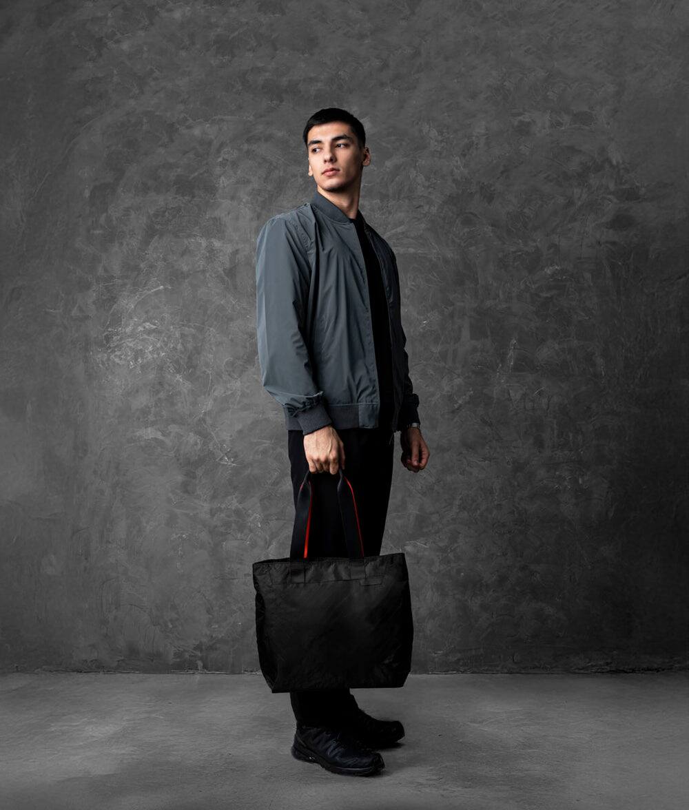 Left. ALPAKA - Elements Tote Bag 14.5L Weatherproof Foldable Travel Tote with Magnetic Closure - Black Axoflux 210D.