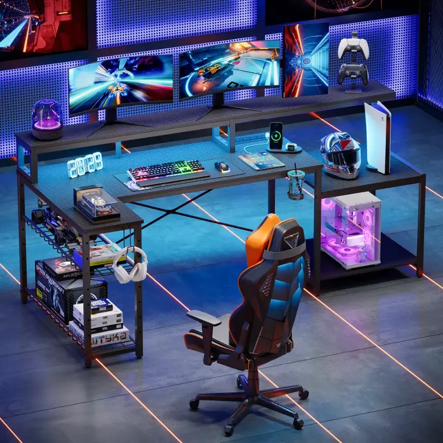 The image features a computer desk with a blue chair and a keyboard. There are multiple monitors on the desk, including a TV and a laptop. A computer mouse is also present on the desk. The desk is set up in a room with a hardwood floor, and there is a helmet placed nearby. Additionally, there are two books on the desk, one of which is a cookbook.