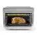 The image shows a Ninja microwave oven with a whole chicken inside, cooking on a rack. The oven is currently set to toast the chicken, and the timer is set to 145 degrees. The oven is designed to cook food quickly and efficiently, making it a popular choice for busy households.