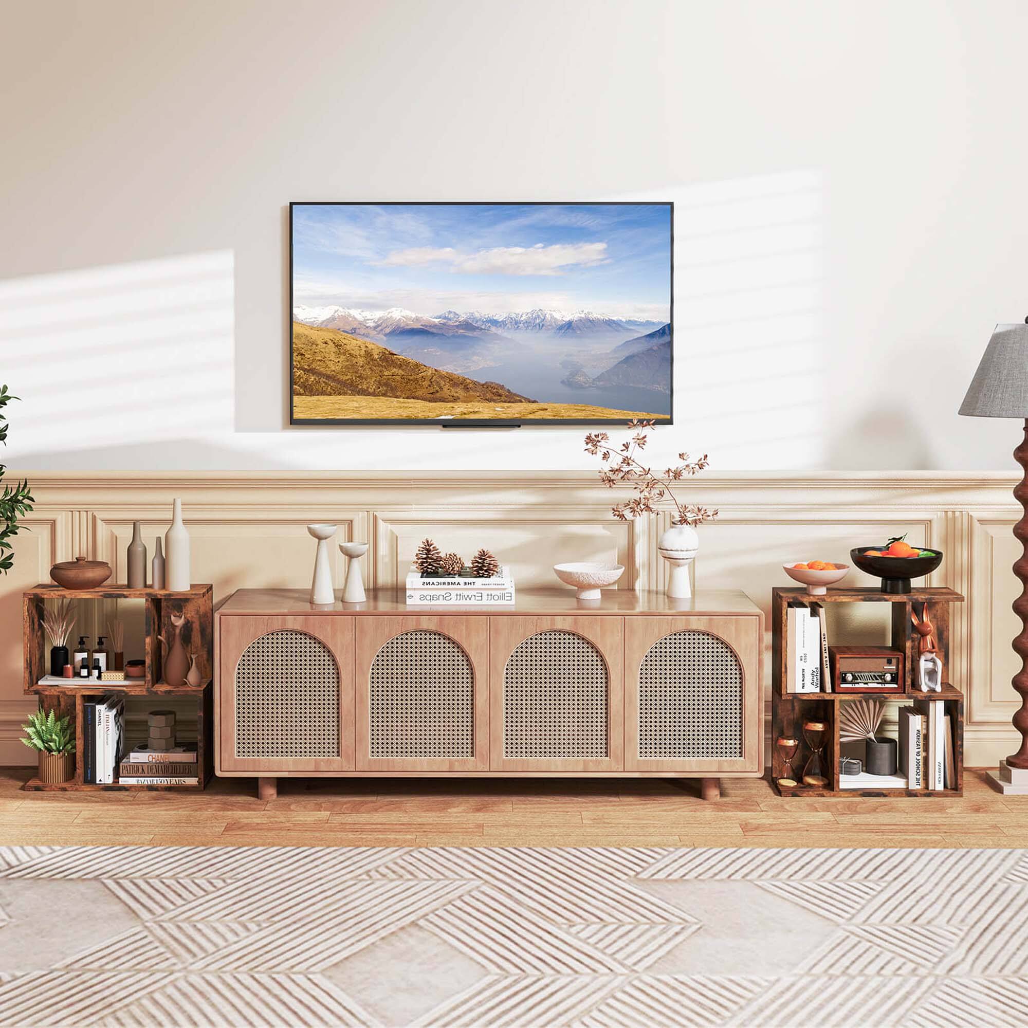 The image features a living room with a large picture hanging on the wall. The room is furnished with a wooden cabinet, a table, and a lamp. The cabinet has a vase and a bowl on top of it, while the table has a bowl and a vase on it. There are also several books scattered around the room. The living room is decorated with a rug and a potted plant, adding to the cozy atmosphere.