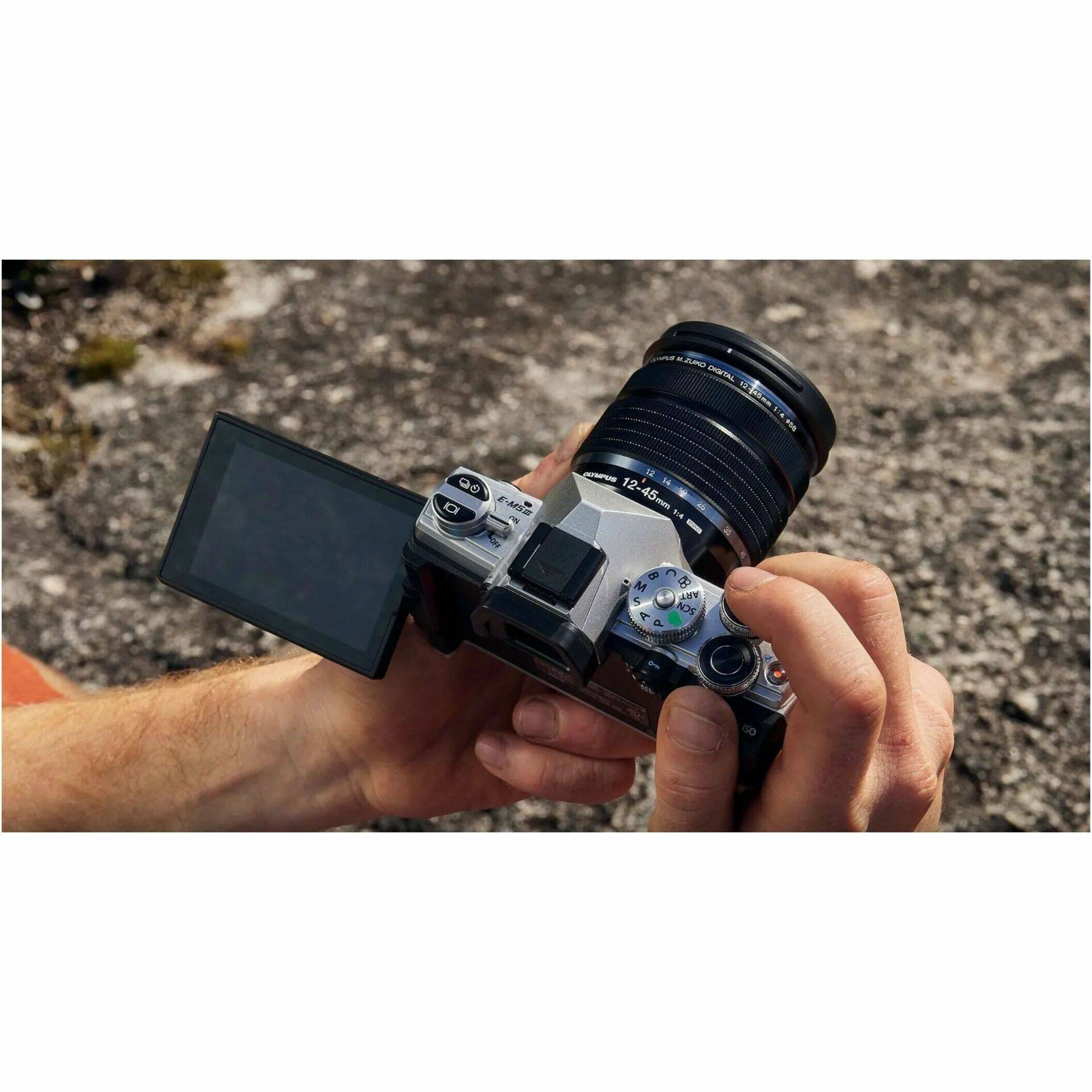 The text on the image reads: "12-45mm & 14-8 C D M 5 AIN T A NOS d - - nD." This text is likely a description or information about the camera lens.