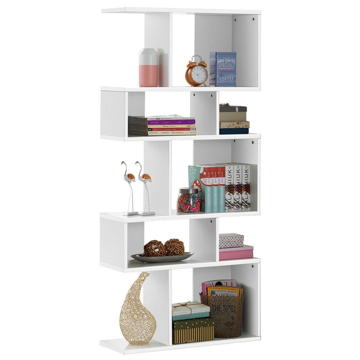 The image features a white bookshelf with various items on it. There are multiple books on different shelves, including a cookbook and a book about knitting. Additionally, there are two bottles, one on the top shelf and another on the bottom shelf. A clock is also present on the top shelf, and a vase is located on the middle shelf. The bookshelf is filled with a variety of items, making it a functional and decorative piece of furniture.