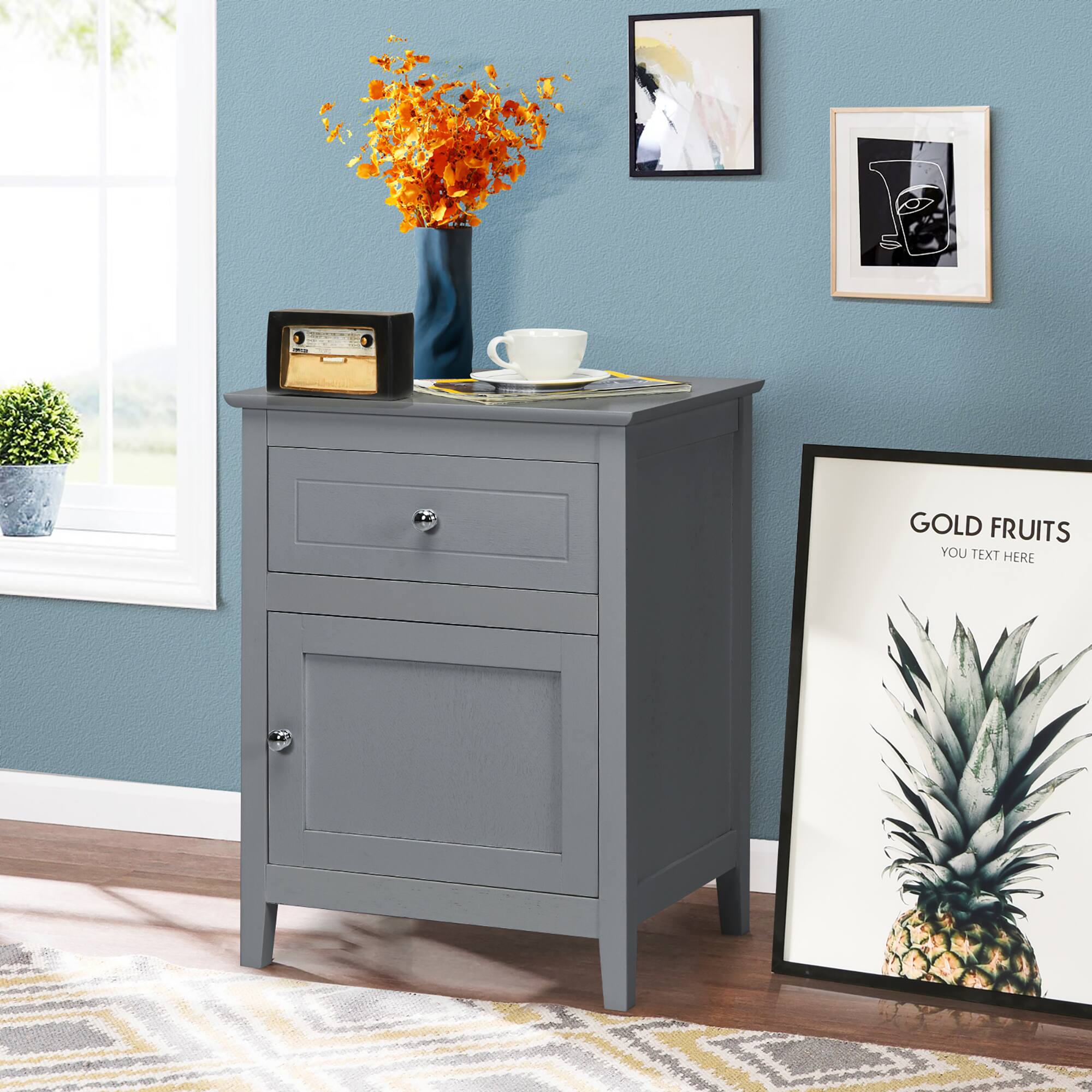 The image features a small table with a vase of flowers and a cup on it. There is also a picture of a pineapple on the table. The table is placed in front of a window, and a potted plant is located nearby. The room has a blue wall, and there are two pictures hanging on it. Additionally, there is a picture of a pineapple on the wall.