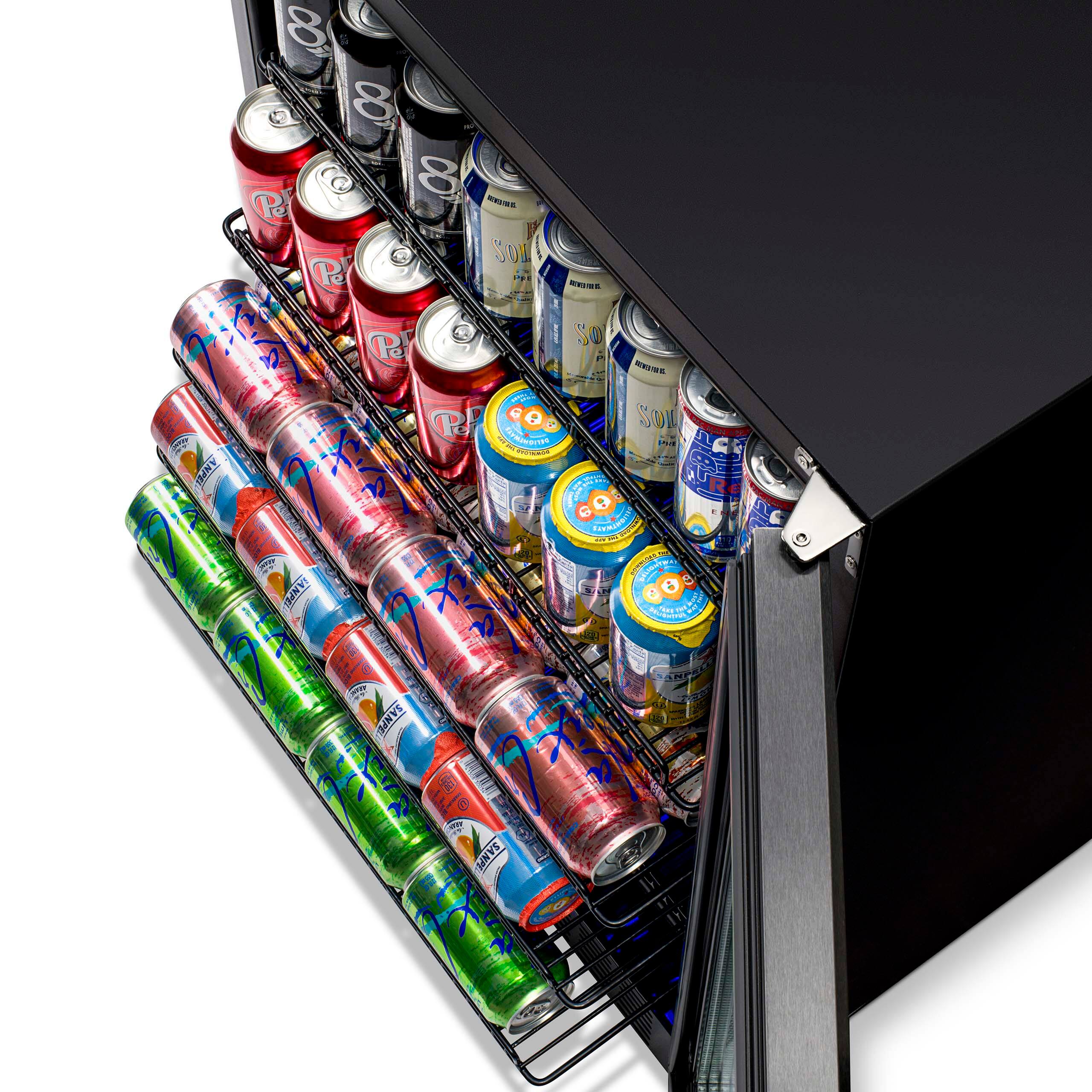 The image shows a black refrigerator with a variety of drinks stored inside. There are multiple cans of soda, including Pepsi, and a few bottles of beer. The drinks are organized on shelves, with some cans placed in a rack and others stacked on top of each other. The refrigerator is filled with a diverse selection of beverages, making it a convenient spot for guests to grab a drink.