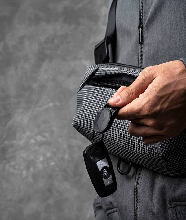 Left. ALPAKA - Lightweight Crossbody Sling Bag for Travel, Phone, Wallet & Passport, Momentum Sling, Weather-Resistant - Axodyne hybrid Grey.