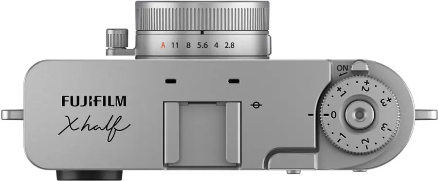 A FUJIFILM XHalf camera with a zoom lens. The lens has a range of 11 to 8, 5.6 to 4, and 2.8 to 1. The camera also has a zoom feature with settings of +1, +2, +3, -1, -2, and -3.