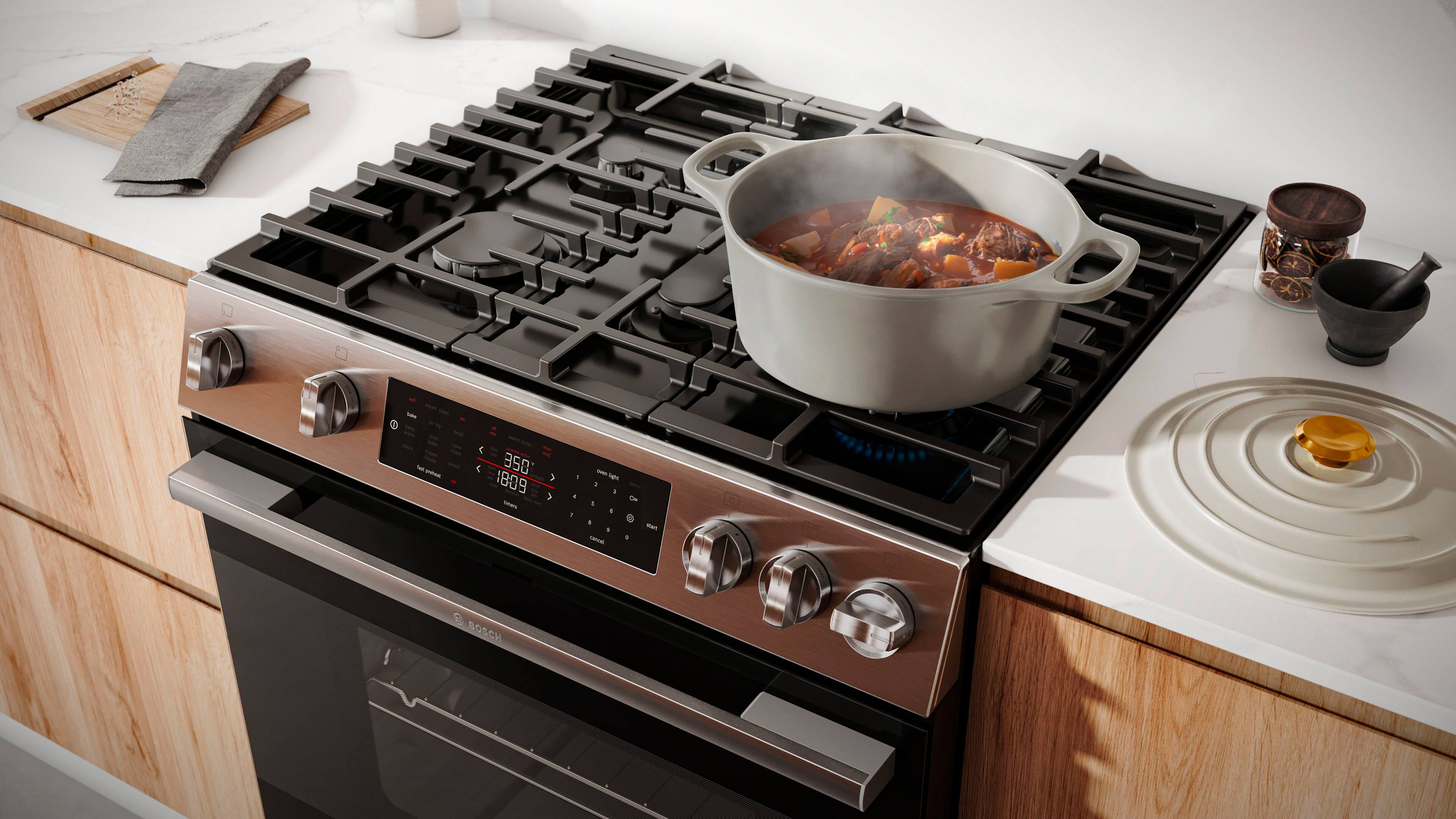 The image shows a stove with a pot of food on it, indicating that it is being cooked at 350 degrees. The stove is a Bosch brand, and the food is being cooked on the stove top. The pot is placed on the stove, and the stove appears to be a black and silver model. The image also shows a bowl on the countertop, possibly for serving the cooked food.