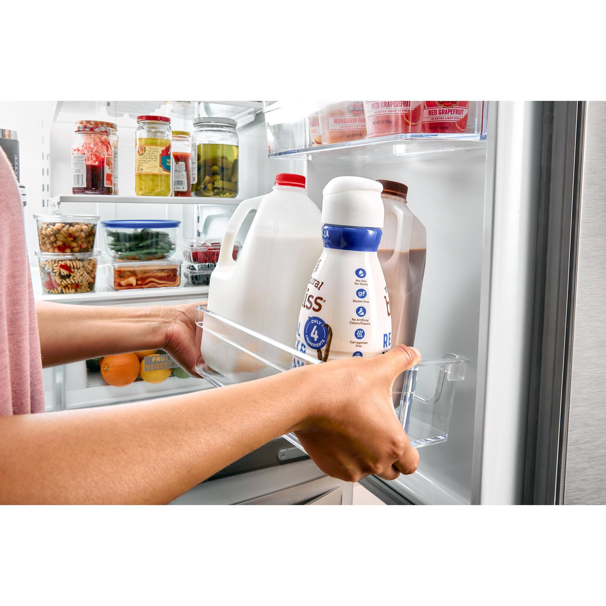 Two containers of Tropicana grapefruit juice are in the refrigerator.