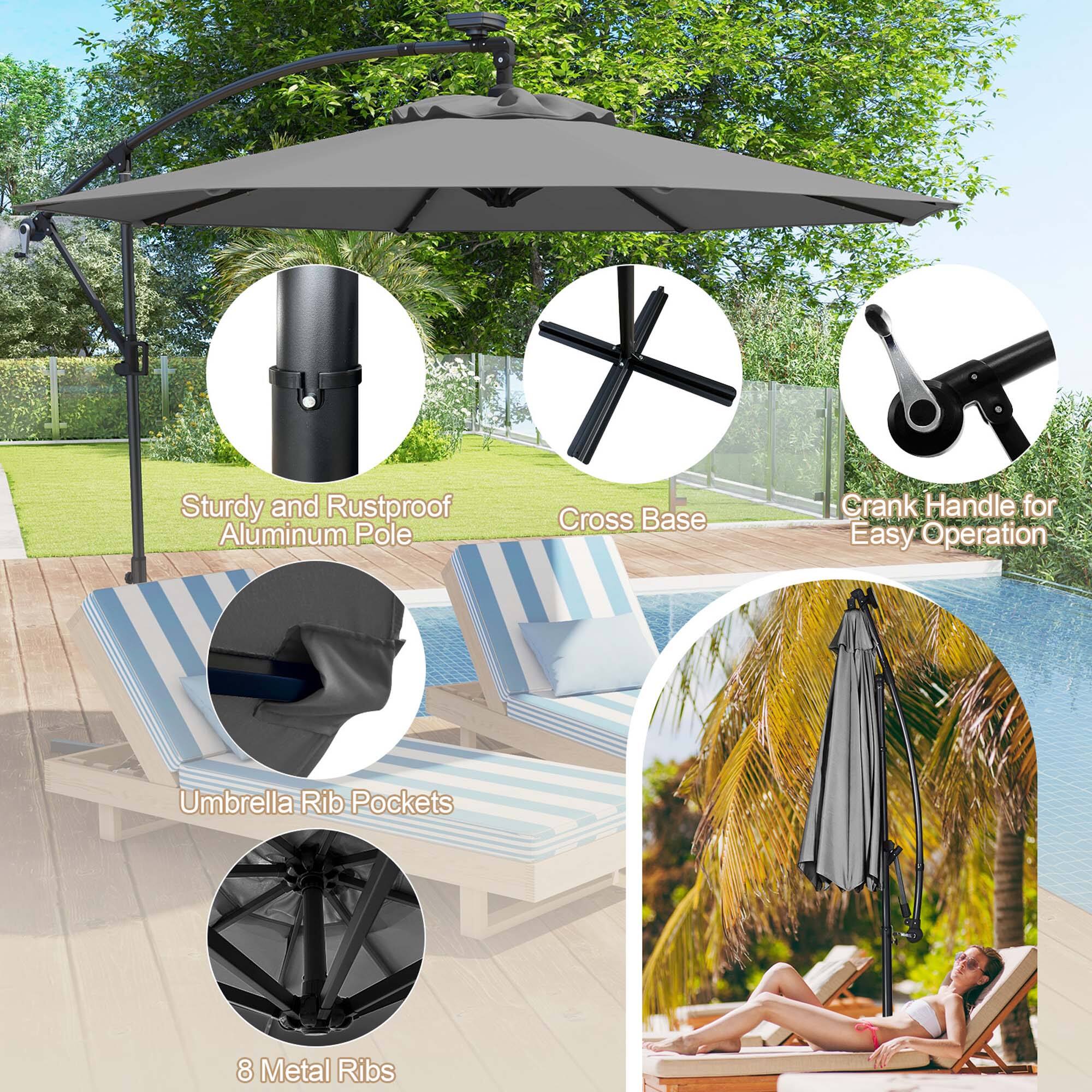 The image features a large umbrella with a black frame and a gray canopy. It is placed on a wooden deck, providing shade for the area. The umbrella is supported by a sturdy and rustproof aluminum pole with a cross base, ensuring stability. The pole also has a crank handle for easy operation. The umbrella has eight metal ribs, which provide additional support and durability. The scene also includes a couple of chairs and a person nearby, making it a comfortable outdoor space.