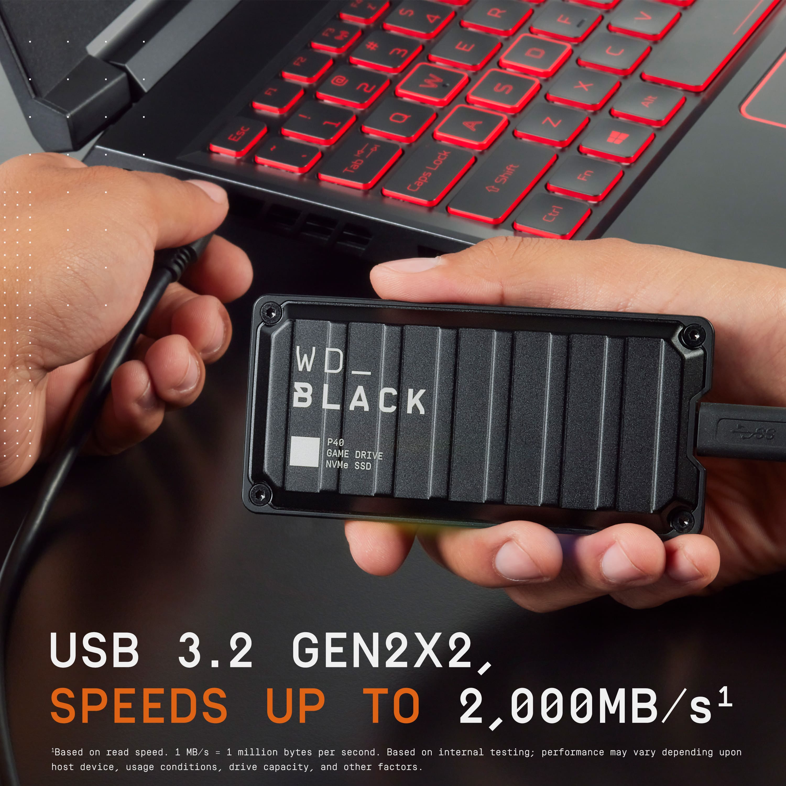 The text on the image reads:
"Esc E ! - ~ S 4 O > F I E I # m E O U ~ S X 1 O A ~ " f Lock Tab Shift Fn Ctrl WD_ BLACK P40 BAME DRIVE NVMe SSD 2ss USB 3.2 GEN2X2, SPEEDS UP TO 2,000MB/s1 Based on read speed. 1 MB/s . 1 million bytes per second. Based on internal testing; performance may vary depending upon host device, usage conditions, drive capacity, and other factors."
The text is about a WD Black P40 NVMe SSD, which is a high-speed storage device with read speeds of up to 2,000 MB/s. The text also mentions the use of a laptop and a thumb drive.