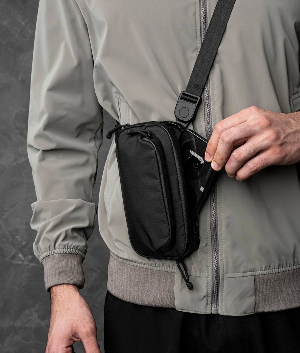 Alt View 2. ALPAKA - Bravo Passport Pouch Sling Bag for Men, Passport Holder for Travel, Fits iPhone Pro Max, RFID, AirTag Sleeve - Black Axoflux 210D.