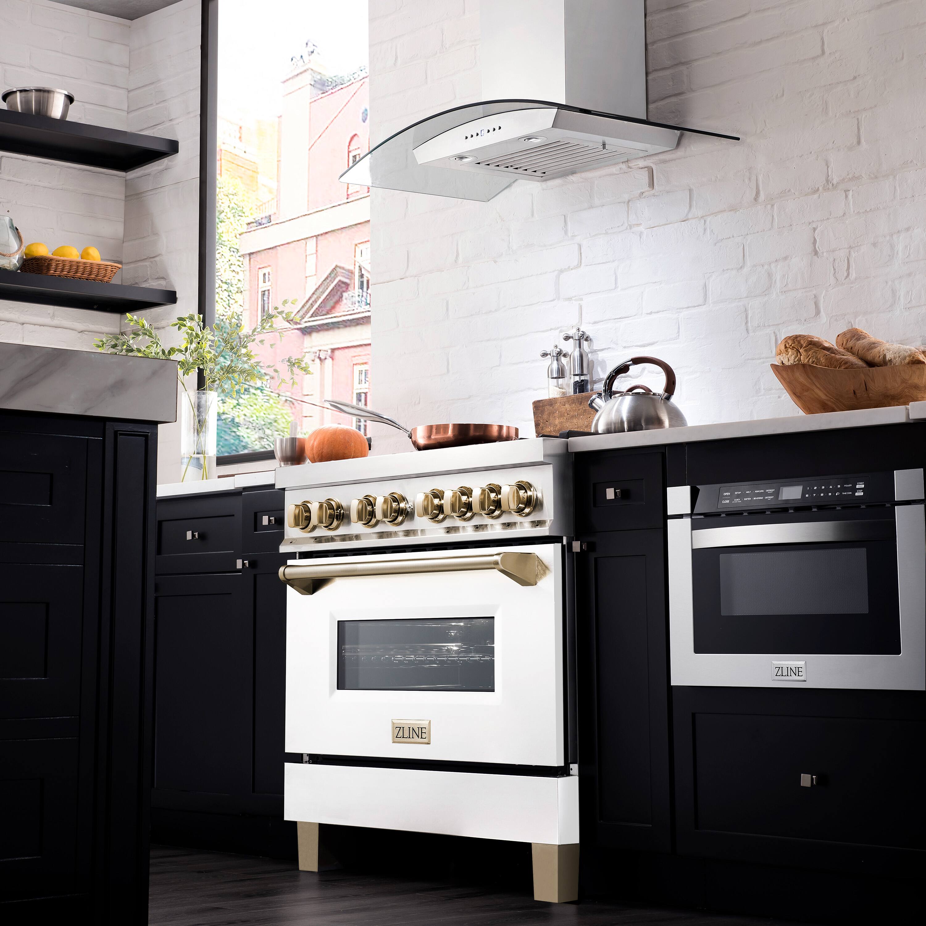The image features a kitchen with a black and white color scheme. The focal point of the kitchen is a white oven with a gold trim, positioned under a ventilation fan. The oven has a gold knob, adding a touch of elegance to the kitchen design. 

In addition to the oven, the kitchen is equipped with a sink, a bowl, and a vase. There are also several oranges placed on the countertop, providing a pop of color to the otherwise monochromatic space. The kitchen appears to be well-organized and functional, with all the necessary appliances and items for cooking and food preparation.