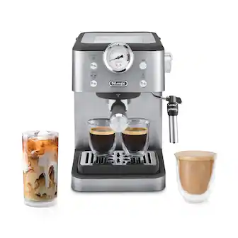 The image features a DeLonghi espresso machine, which is a coffee maker. The machine has a timer on it, and it is set to make two cups of coffee. There are two cups of coffee on the machine, and a glass of iced coffee is also present. The machine is ready to make more coffee, and it is placed on a counter.
