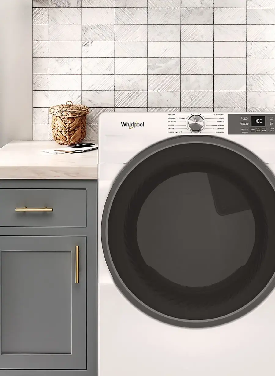 The image features a washing machine and dryer, both made by Whirlpool. The washing machine is located on the left side of the image, while the dryer is on the right side. The dryer has a large black door, and the washing machine is white. The image also shows a basket on the countertop, possibly for holding laundry items.