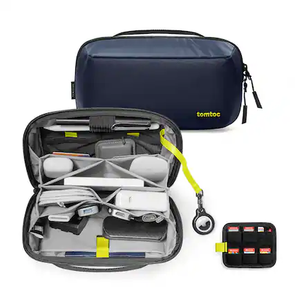 The image shows a blue and black bag with a yellow strap, which is open to reveal its contents. The bag is filled with various items, including a laptop, a mouse, a cell phone, a wallet, and a book. There are also two CDs in the bag. The bag appears to be a travel bag, as it is filled with essential items for a trip. The open bag and its contents are displayed prominently in the image.